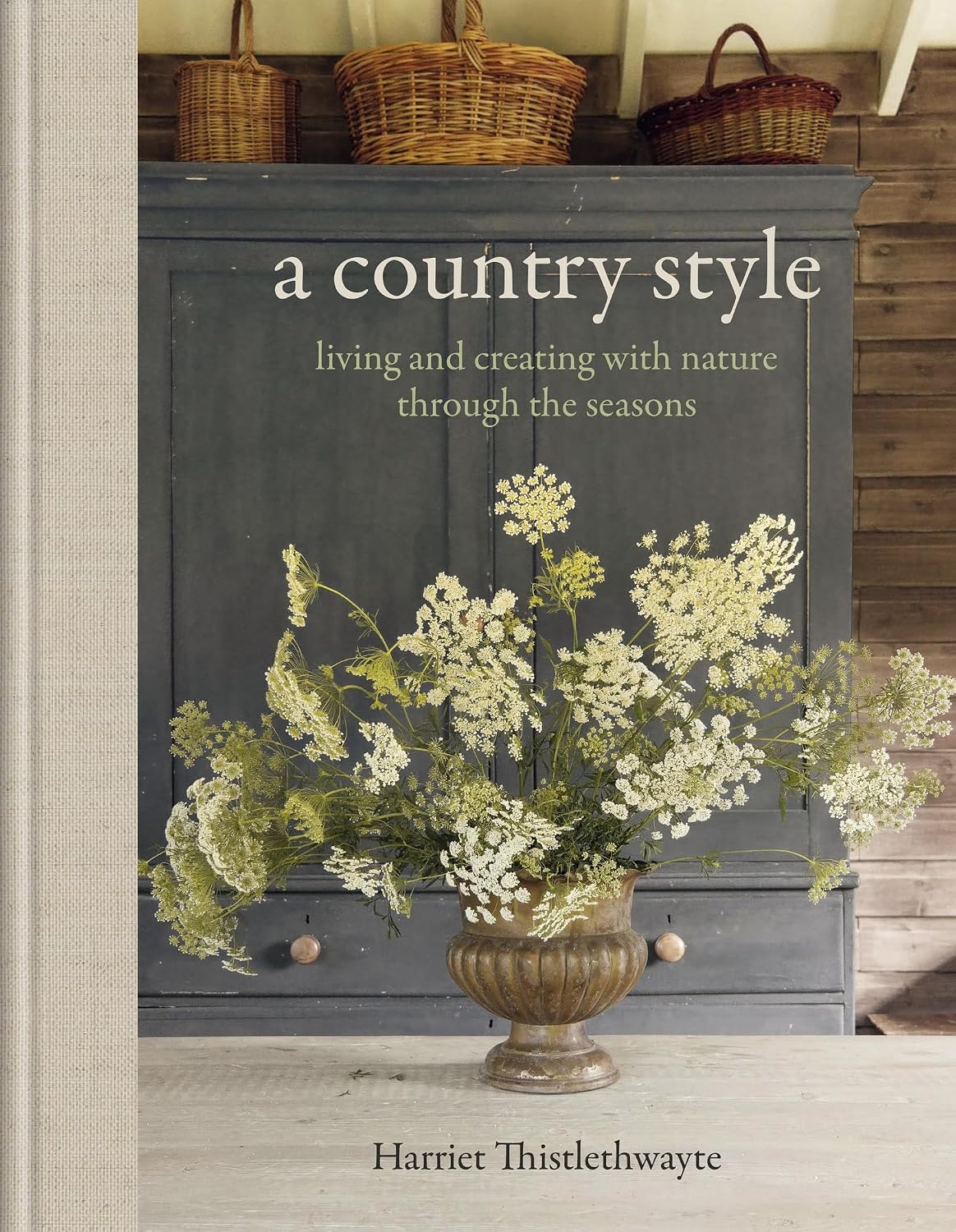 Book cover of 'A Country Style' by Harriet Thistlethwayte with a decorative cabinet and floral arrangement.