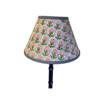 Floral patterned lampshade on a white background on navy wooden lamp