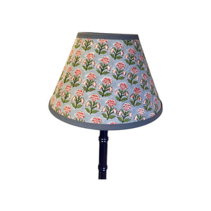 Floral patterned lampshade on a white background on navy wooden lamp