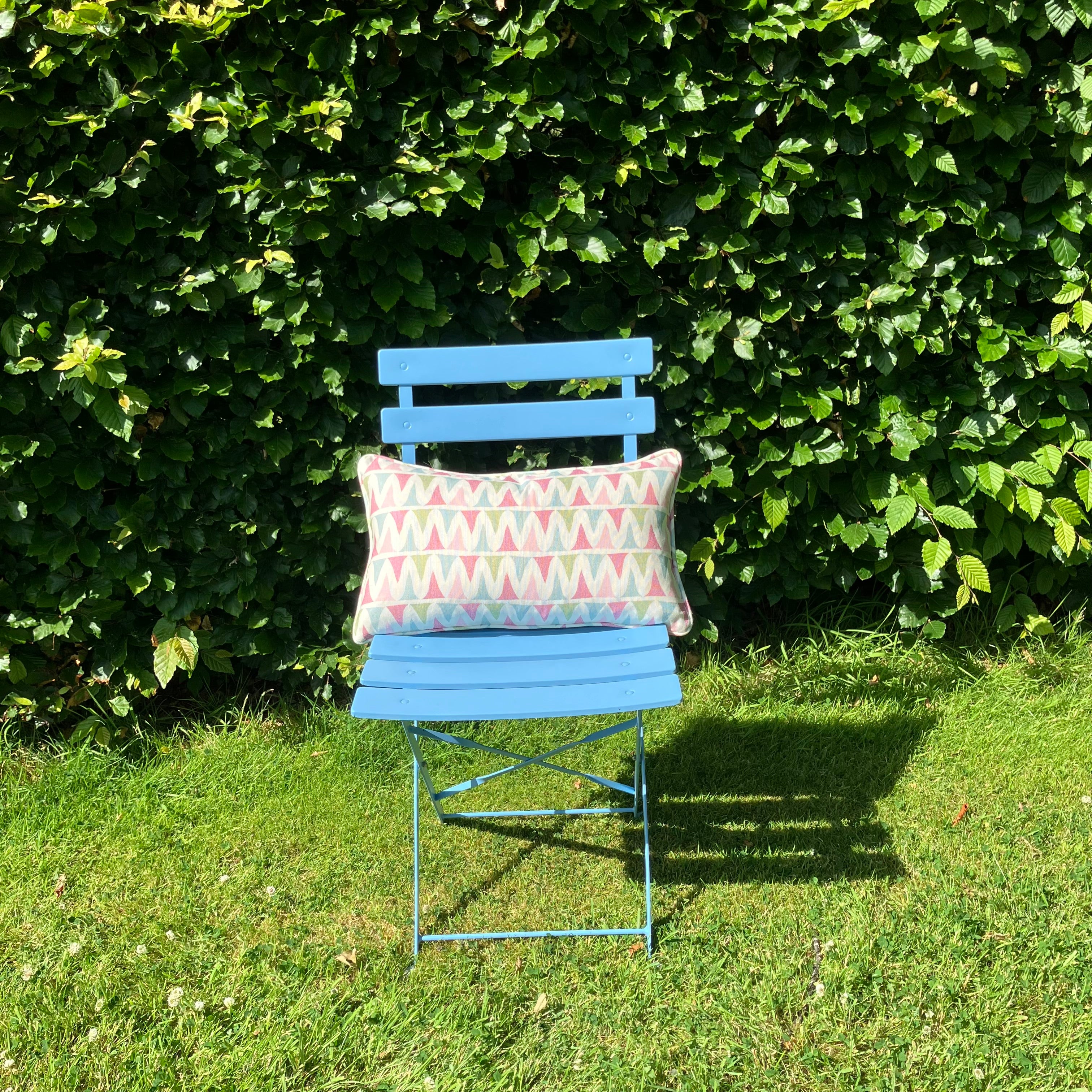 Multi colour rectangle cushion on blue chair in garden