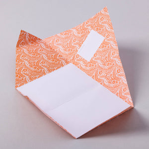 Decorative orange and white patterned fabric on a plain background