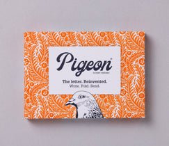 Pigeon letter writing kit packaging with orange and white design on a gray background