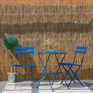 Blue metal outdoor furniture set with two chairs and a table against a bamboo wall.