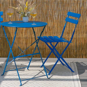 Blue metal table and chairs set on a patio with a bamboo wall background