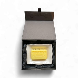 Yellow soap bar in a black box on a white background