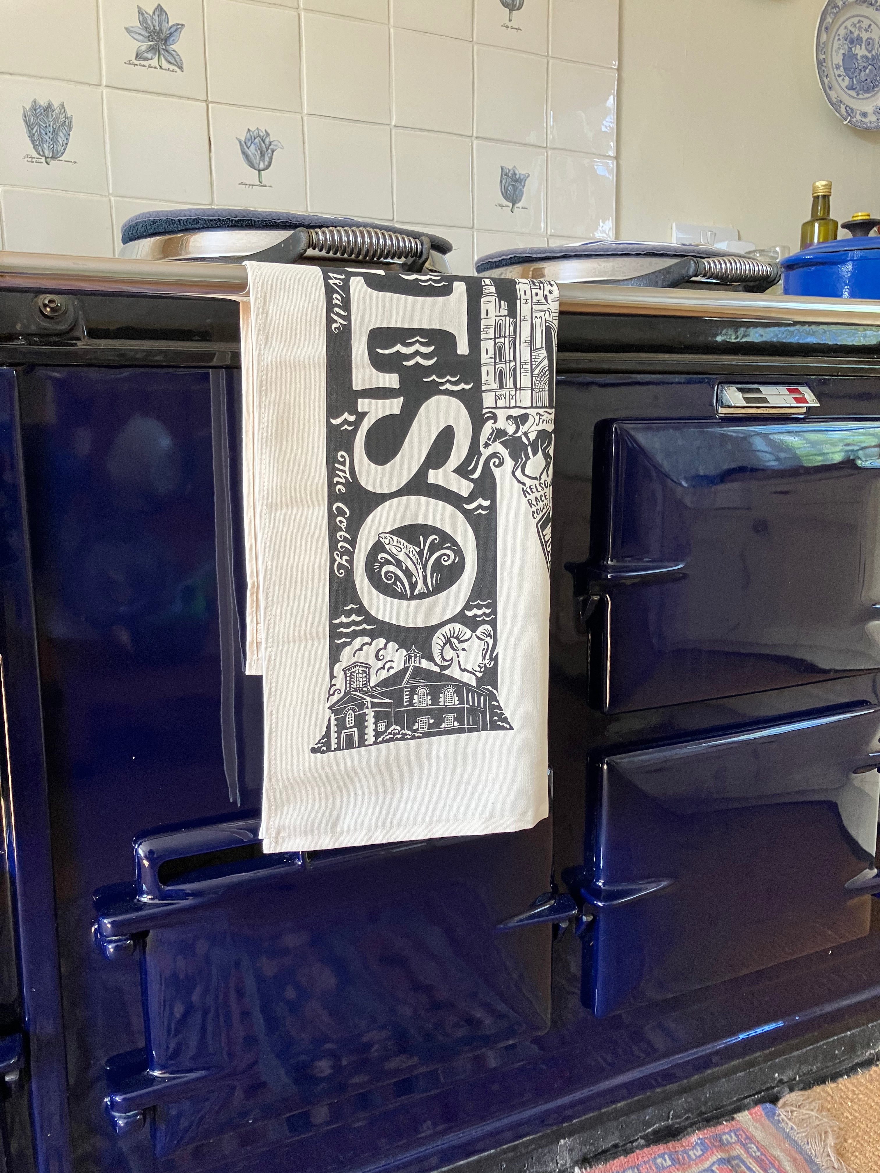 Tea towel with 'kelso' design hanging on a blue Aga range cooker.