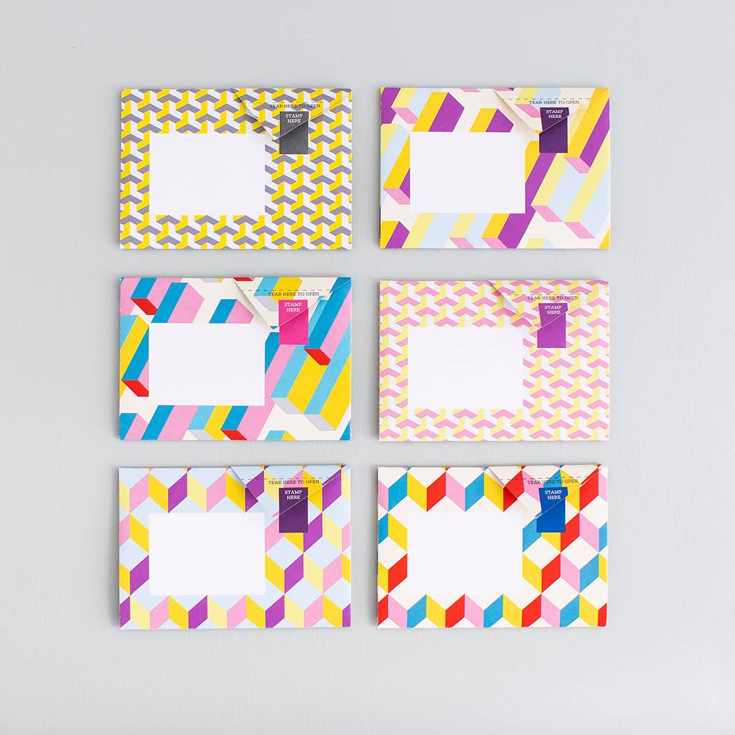 Set of six colorful geometric patterned notebooks on a gray background