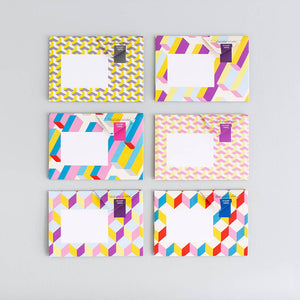 Set of six colorful geometric patterned notebooks on a gray background