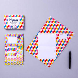 Colorful geometric patterned stationery set on a gray background