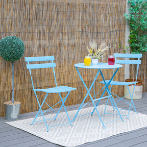 Blue outdoor table and chairs set with drinks on a wooden deck.